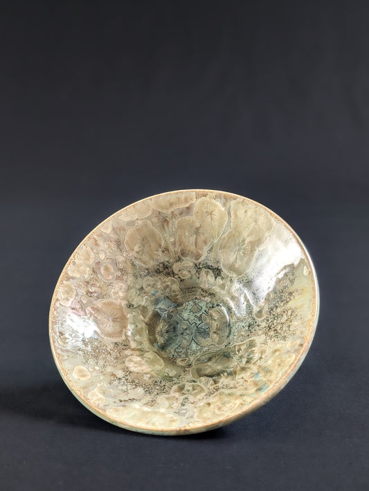 Ceramic bowl with crystalline surface on a dark background