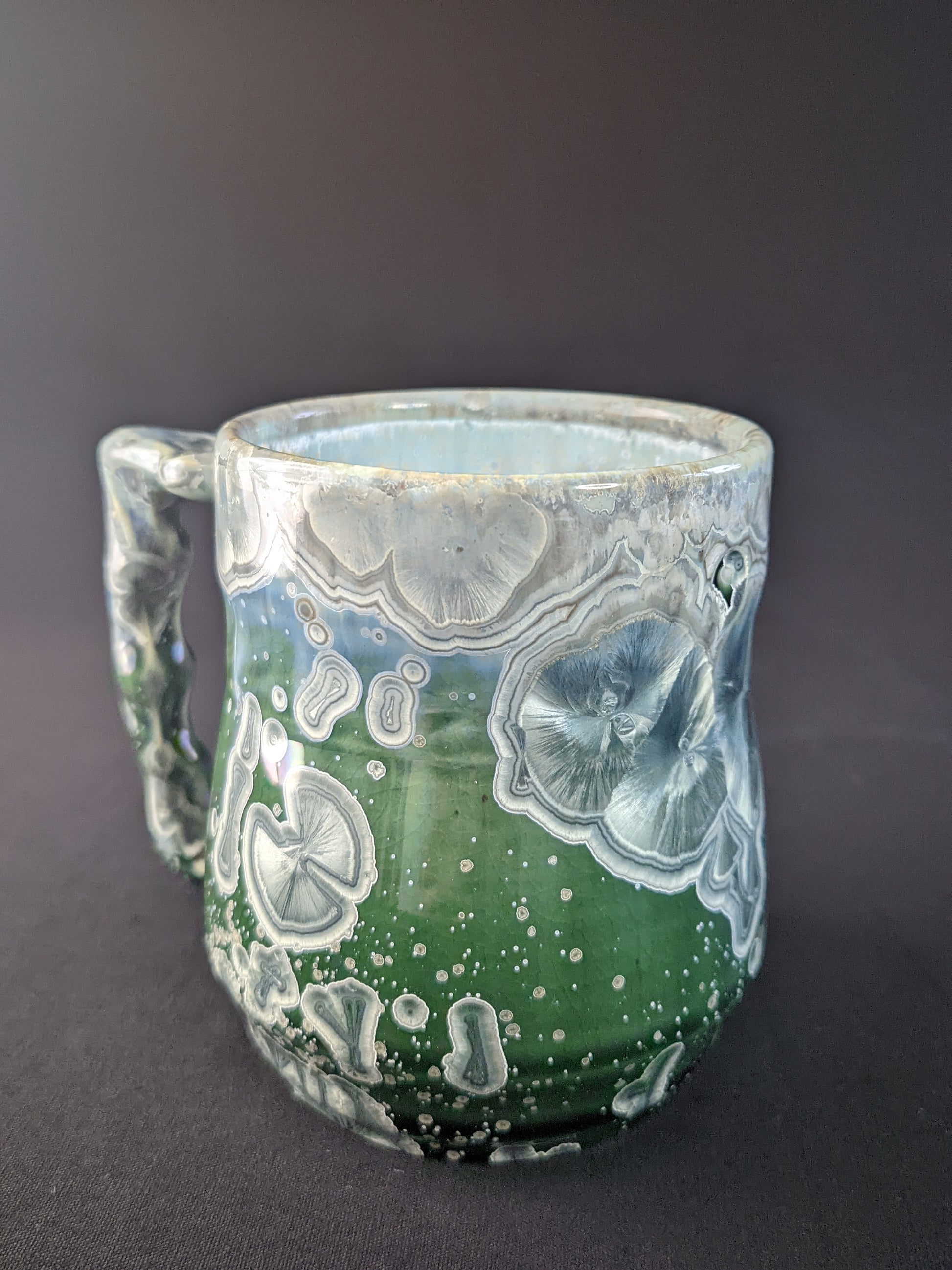 Handcrafted Aurora's Embrace Mug featuring a striking blend of deep blues and purples, with delicate patterns inspired by the Northern Lights, and a smooth, ergonomic handle for a comfortable grip.