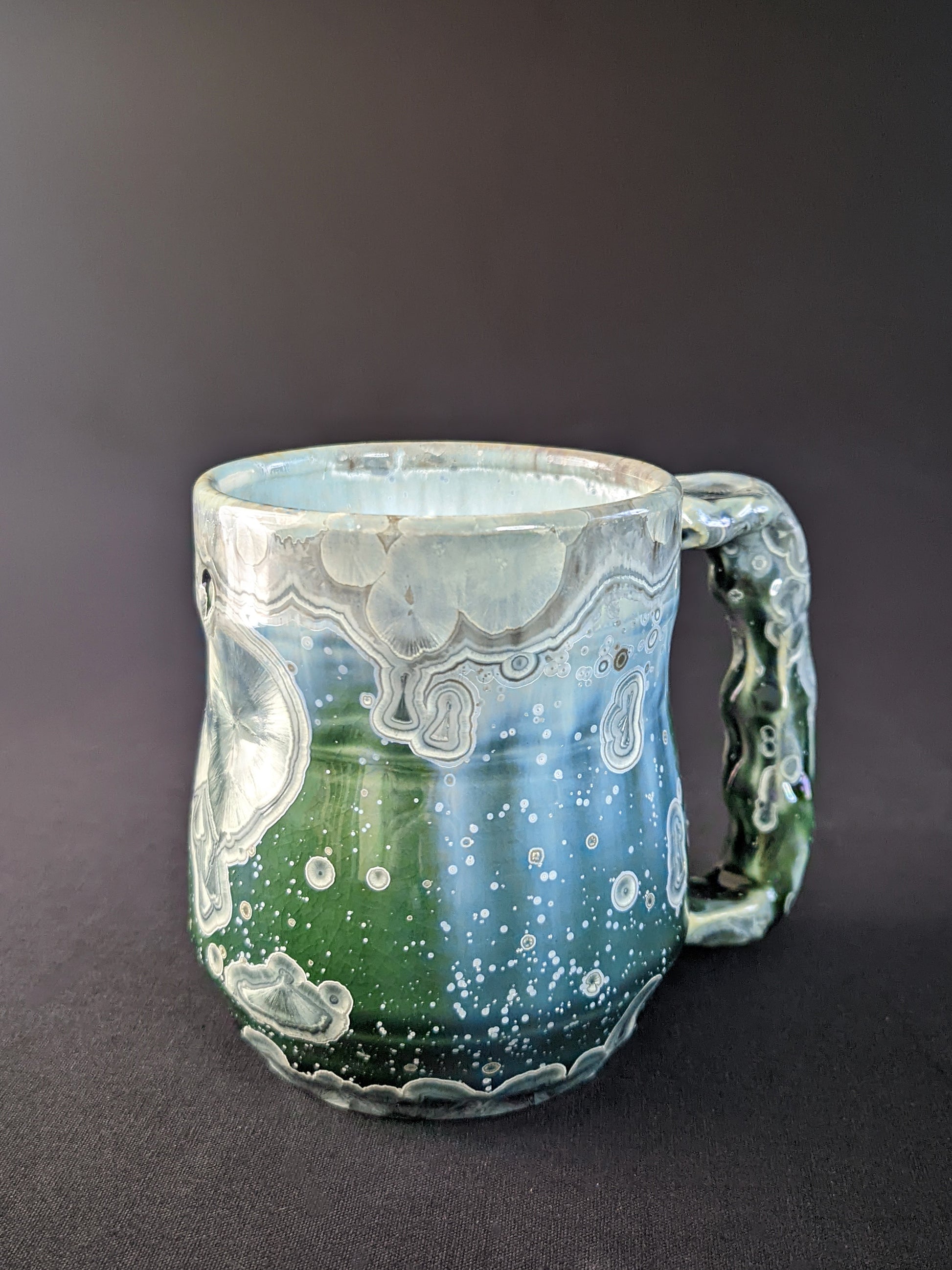 Handcrafted Aurora's Embrace Mug featuring a striking blend of deep blues and purples, with delicate patterns inspired by the Northern Lights, and a smooth, ergonomic handle for a comfortable grip.